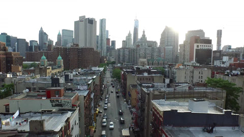 Manhattan skyscrapers view backing up into Chinatown street from high aerial view above buildings in NYC