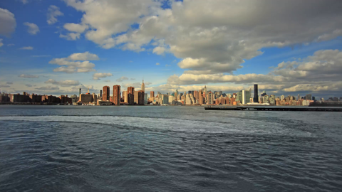 Manhattan skyline timelapse during the day from across river water - skyscrapers in 4K
