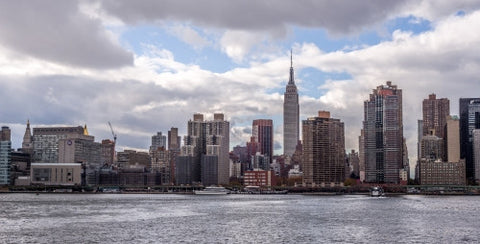 Empire State Building in daytime skyline from across East River water in Manhattan NYC