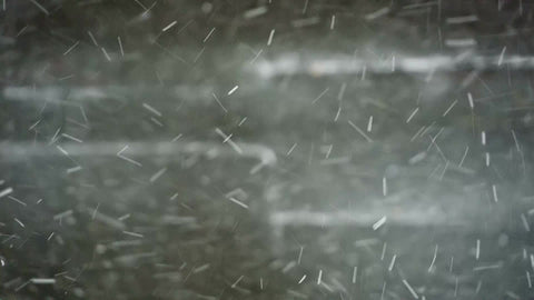 snow in blizzard, snowing in winter, snowflakes flying around against brick wall in storm