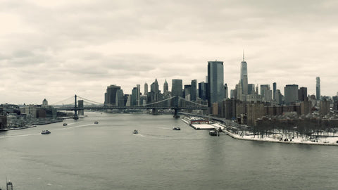 aerial moving toward Freedom Tower and Manhattan Bridge with skyline over East River in New York City NYC