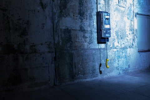 gritty dirty dangling public payphone in subway station in Brooklyn - off the hook