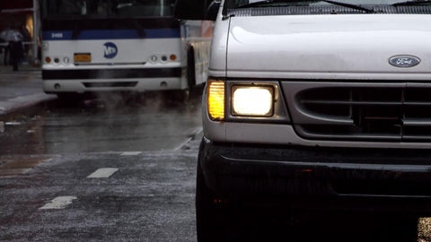 van in rain with MTA bus and woman with umbrella on rainy day in slow motion